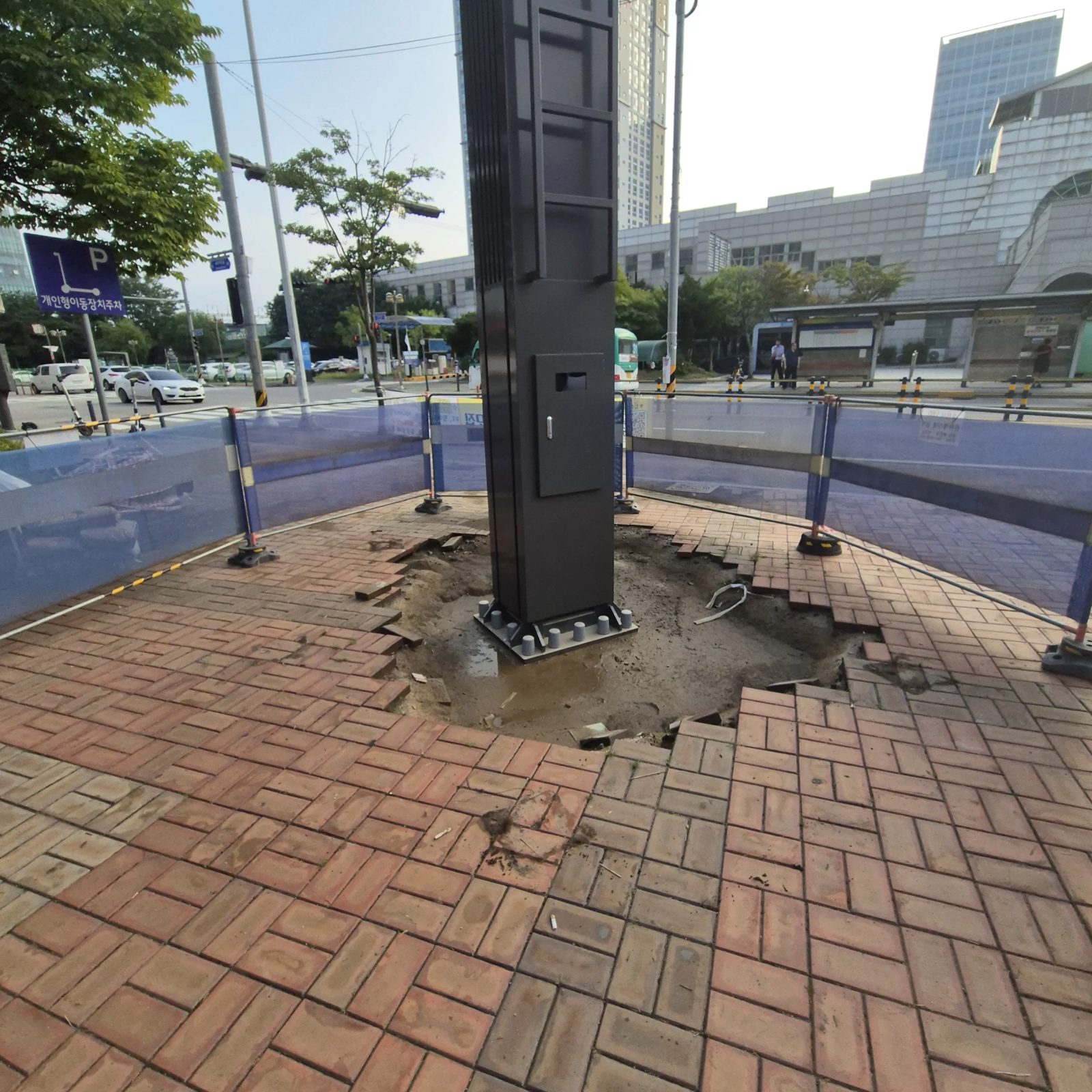 가로등 기둥 둘레 보도블럭이 들뜨고 꺼진 자리